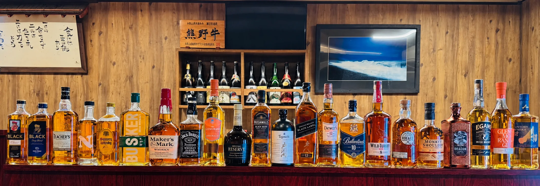 Whisky bottles lined up on the shelves behind the counter